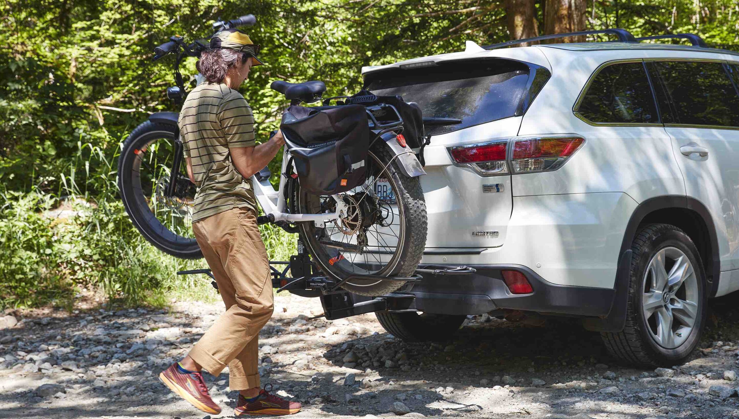 A man in the woods places his RadRover 6 Plus on a car rack.